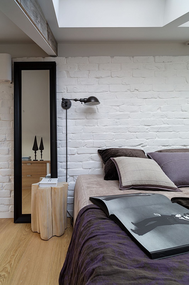 Męski charakter mieszkania podkreślony białą, ceglaną ścianą