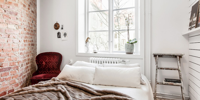 Stara ceglana ściana w malutkiej sypialni – małe też jest piękne